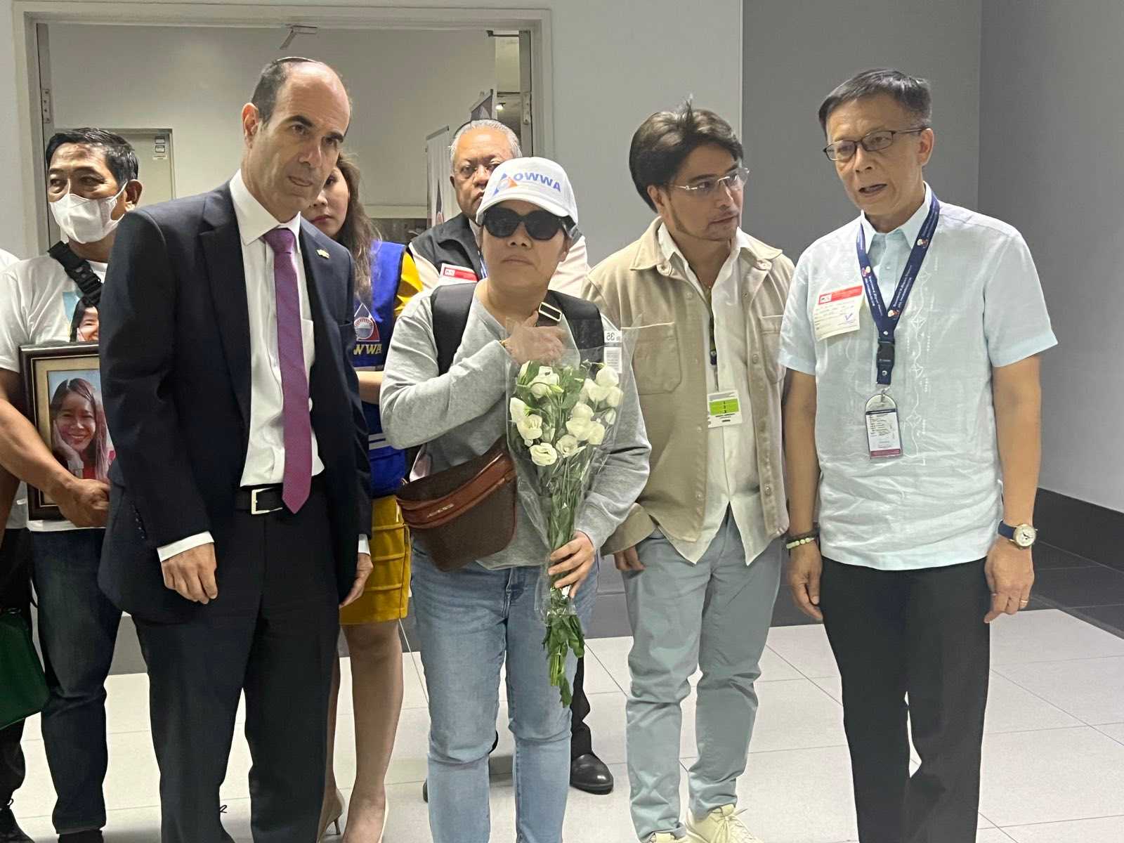5th batch of OFWs from Israel, including remains of Pinay victim, arrives at NAIA