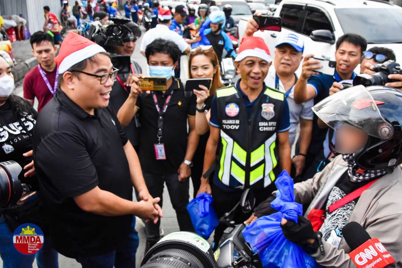 MMDA officials, enforcers distribute grocery packs to motorists along EDSA
