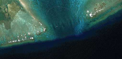 Satellite images reveal floating barrier at mouth of disputed atoll in South China Sea