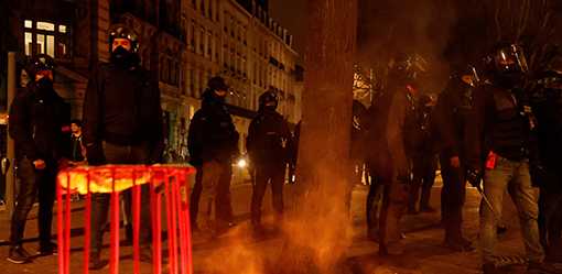 Protesters set rubbish on fire as French govt barely survives no-confidence vote